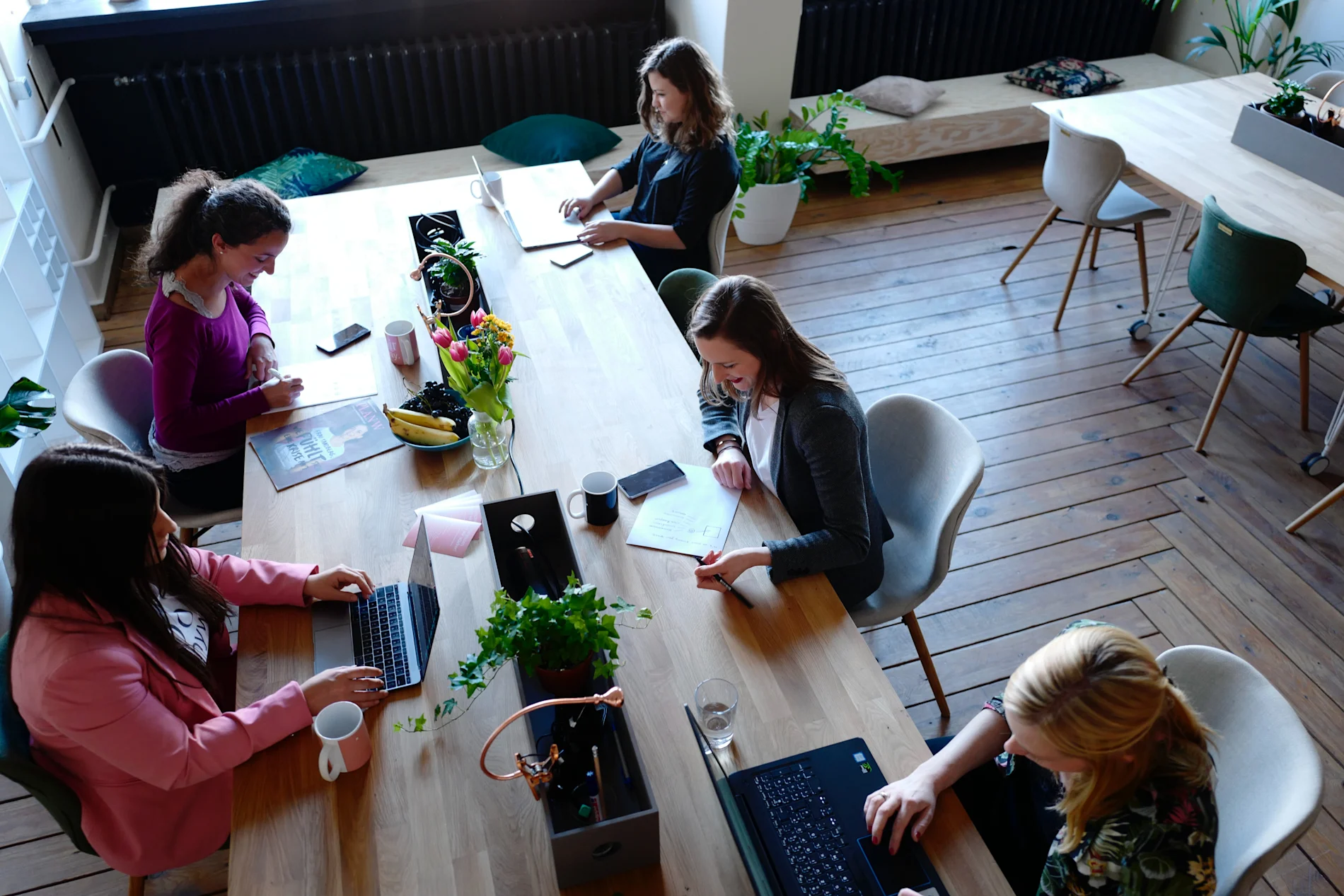 Five women sharing a table at CoWomen – a collaborative work space for women in leadership