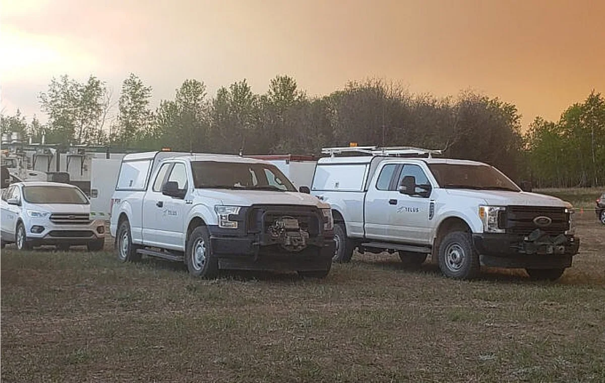 TELUS fleet vehicles parked on a field.