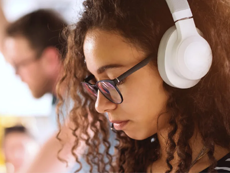 A young woman wearing a pair of white headphones