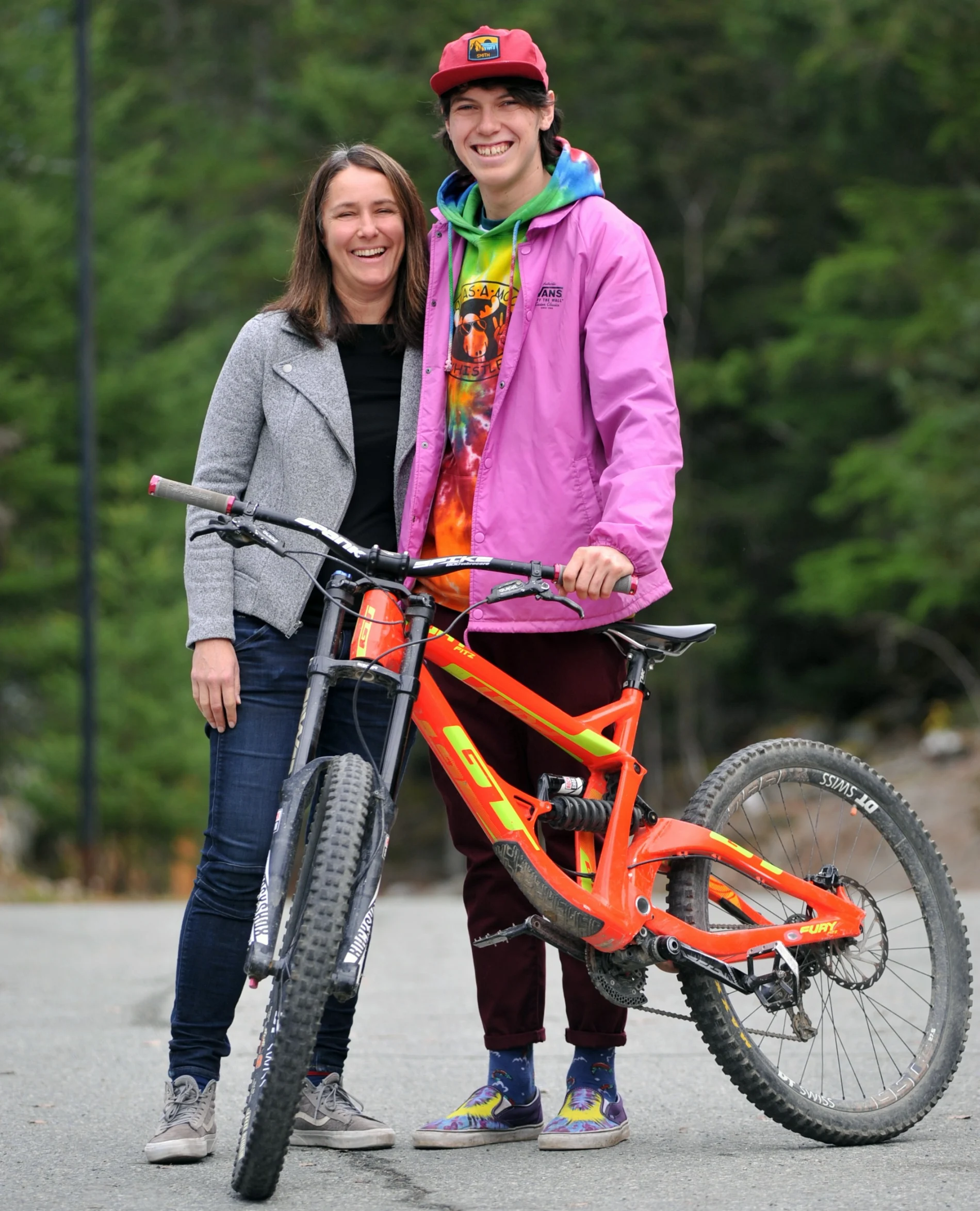 Dakota Williams with his mom, standing in front of a bicycle