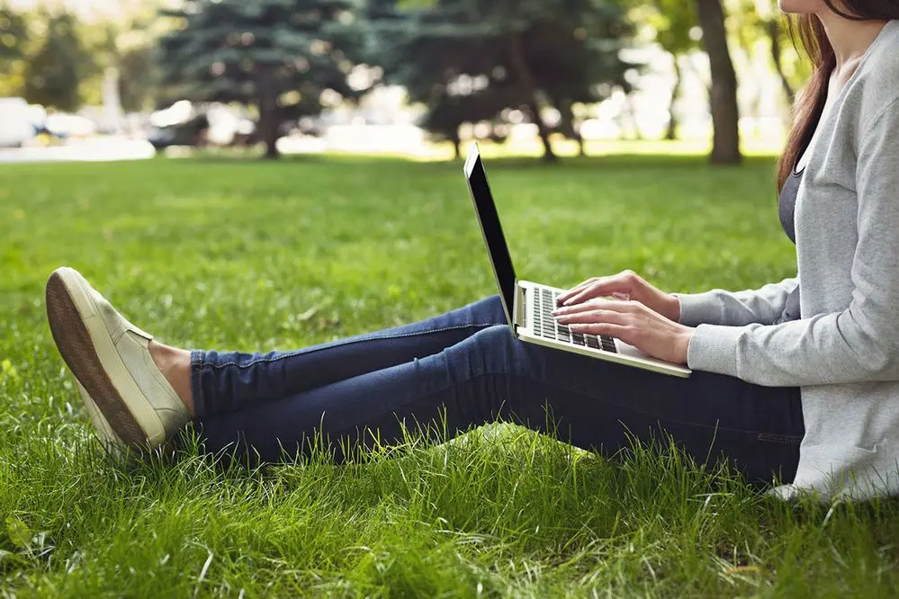 woman-working-laptop-park-grass
