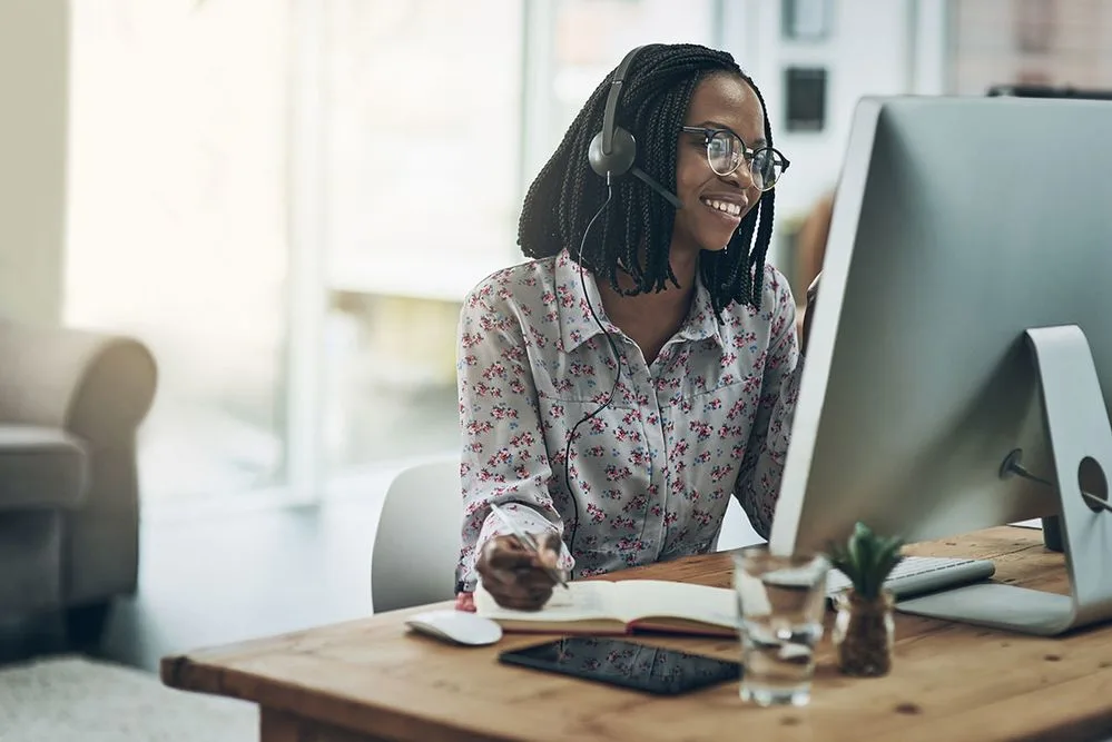 woman-using-a-headset-and-computer