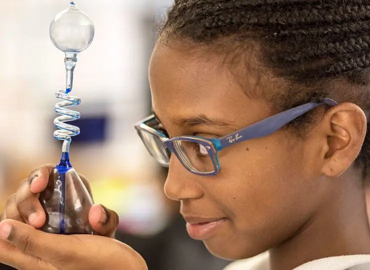 Young girl examining at lab beaker