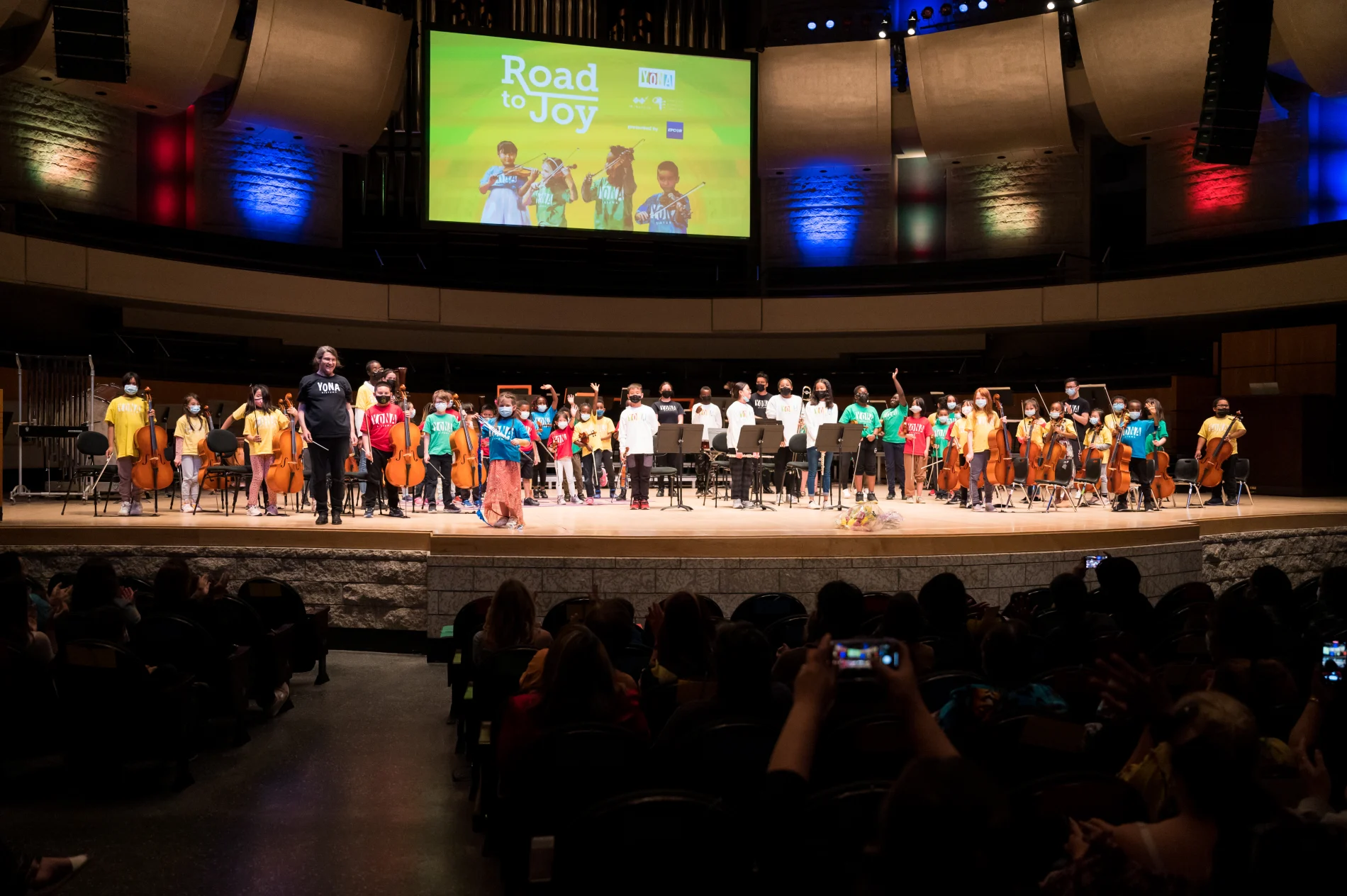 YONA students performing on-stage in front of an audience during the Road to Joy year-end concert.