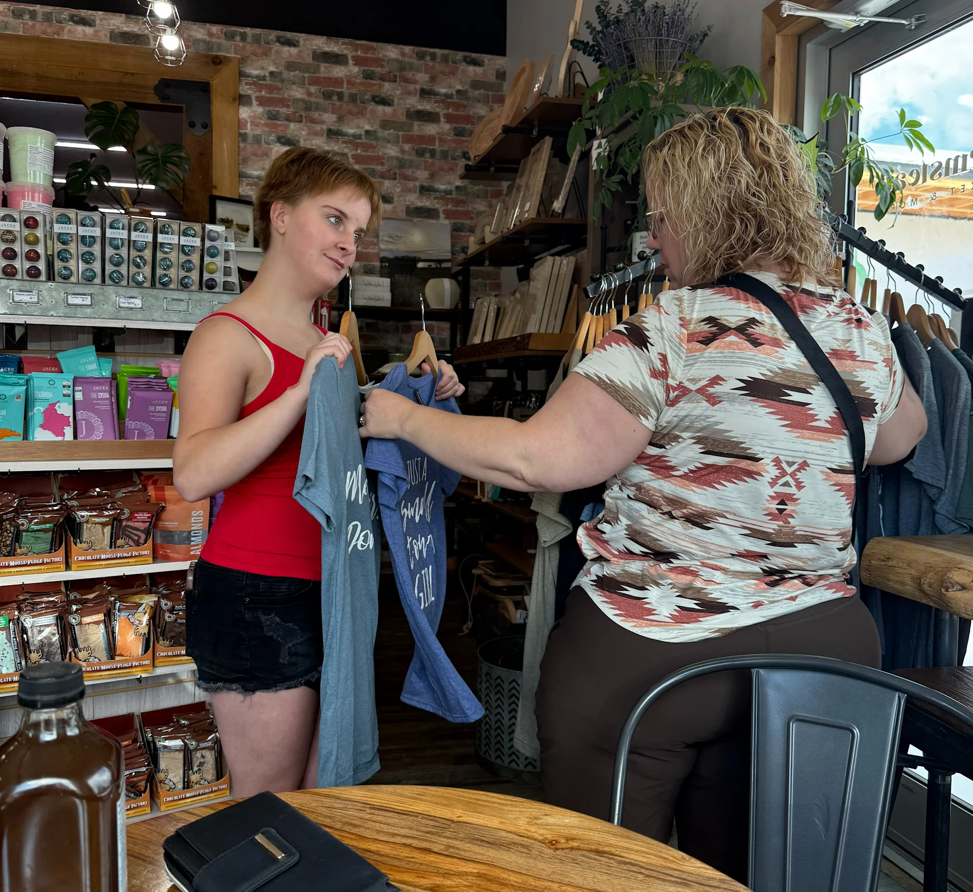 Youth participant from Inclusion Lloydminster working with a customer in a shop. 

