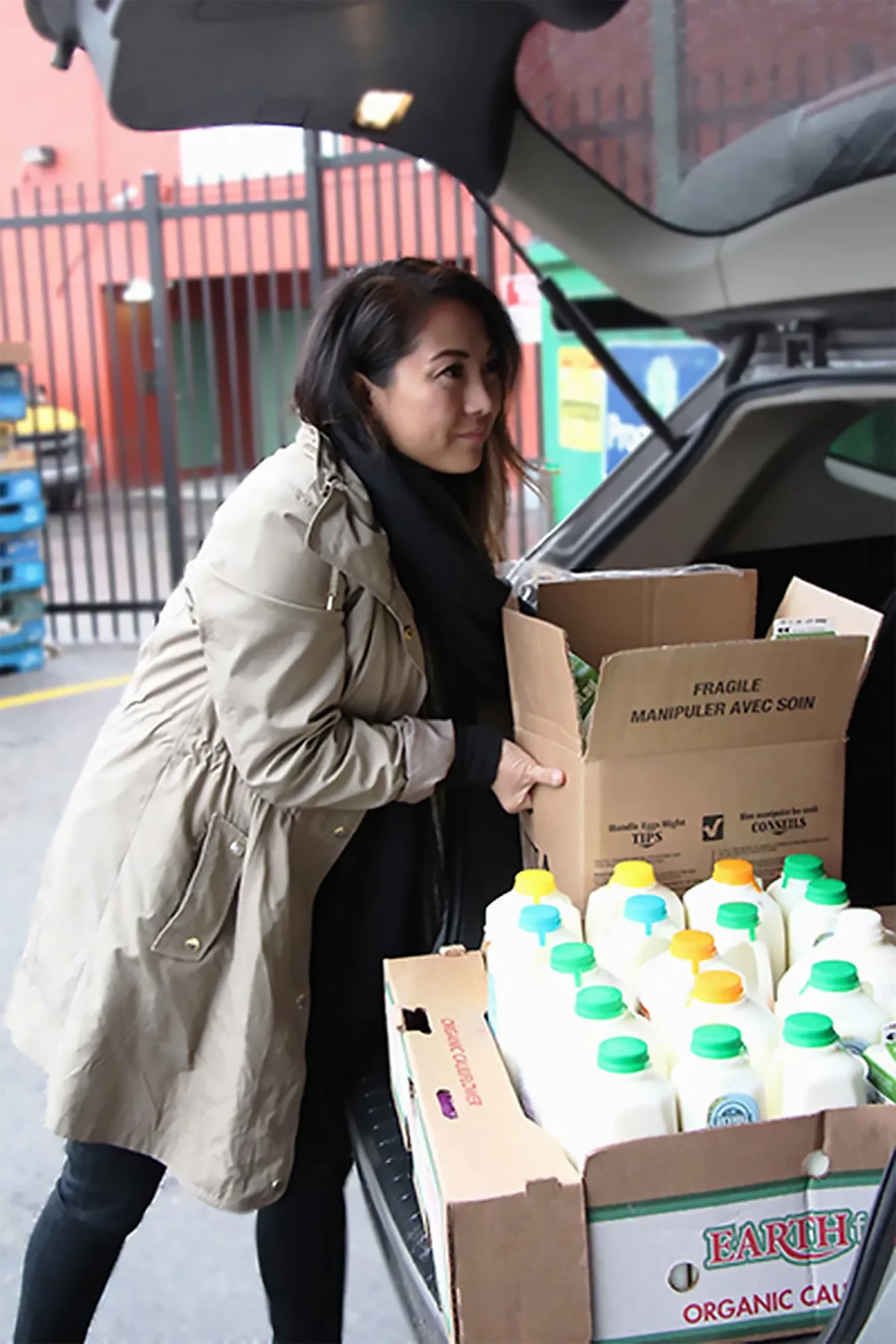 Lourdes Juan place des boîtes de nourriture dans un véhicule.

