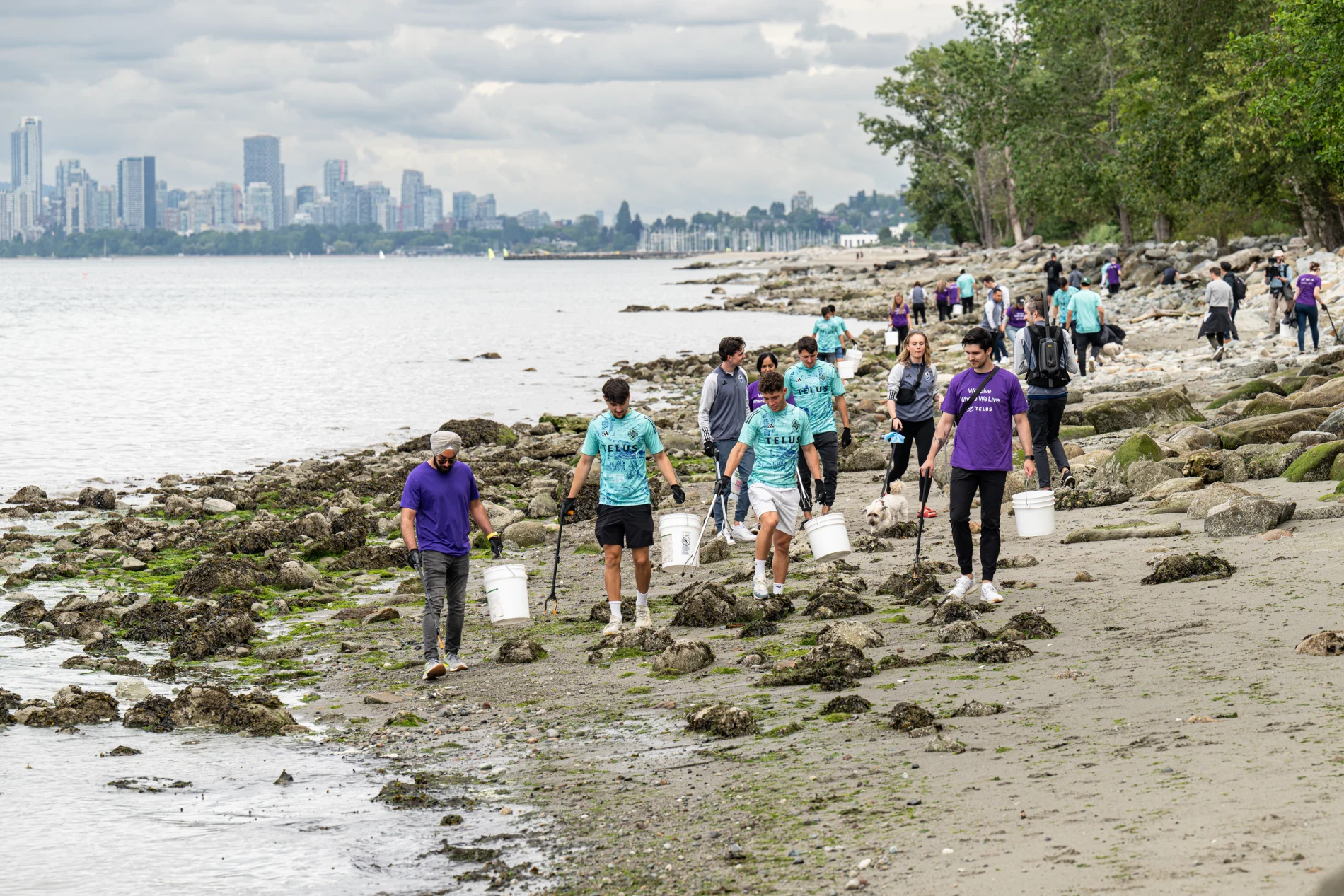TELUS team members picking up waste in a shoreline cleanup.