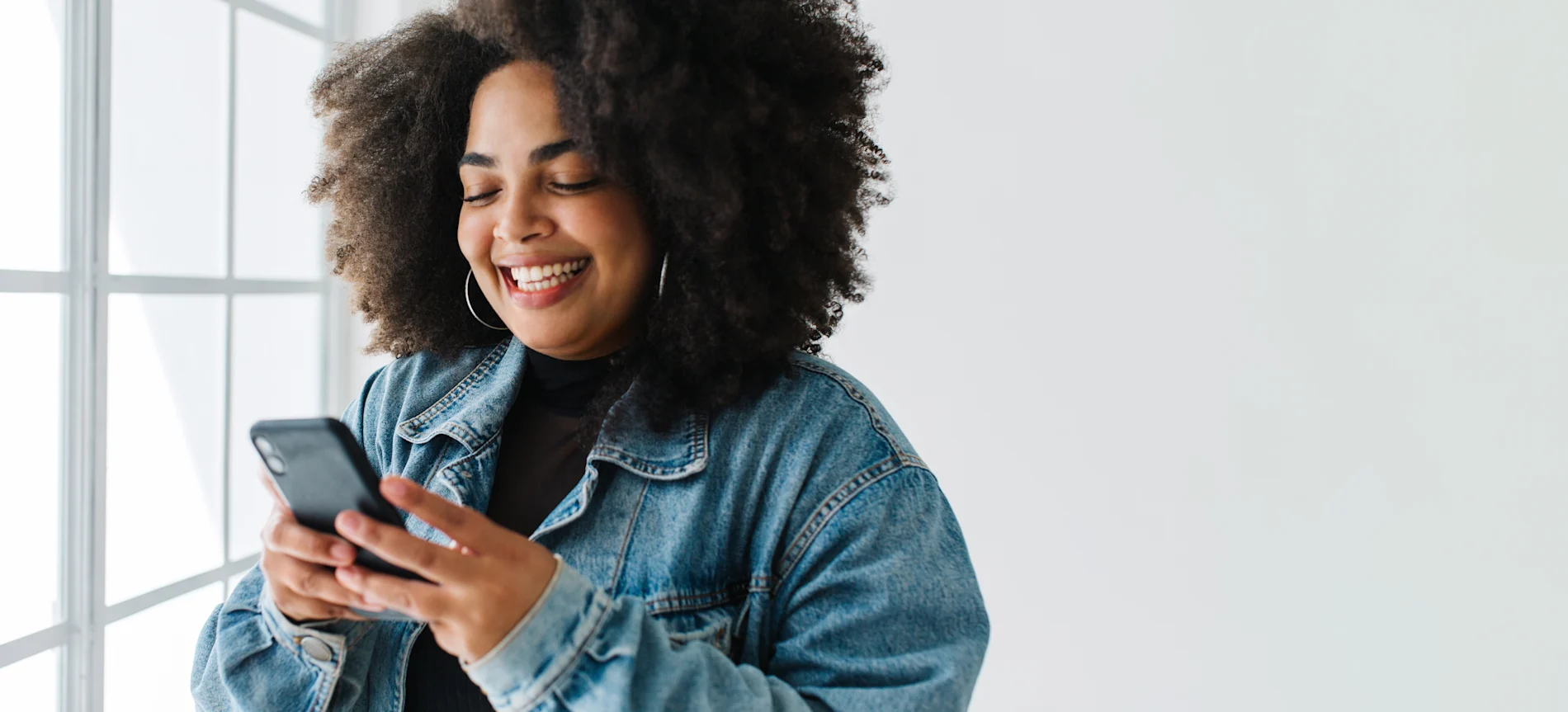 Woman smiling while researching weight loss medication options on her smartphone