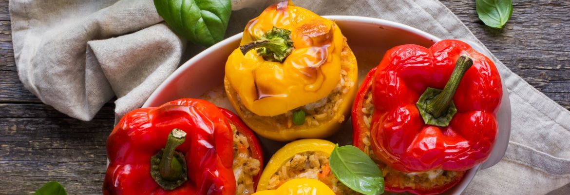 Delicious roasted red and yellow pepper stuffed with beef on a wood table - an easy healthy recipe.