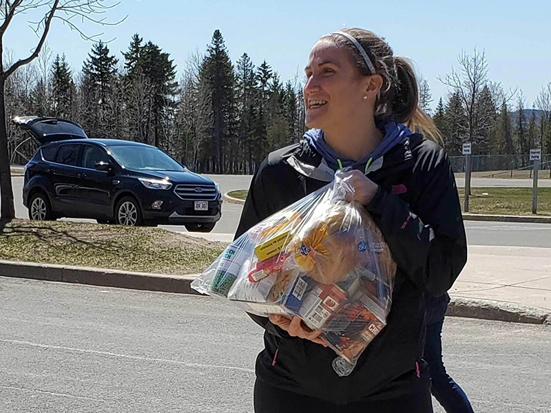Fredericton Community Kitchens executive director, Cassandra Blackmore, holding a bag of food destined for delivery
