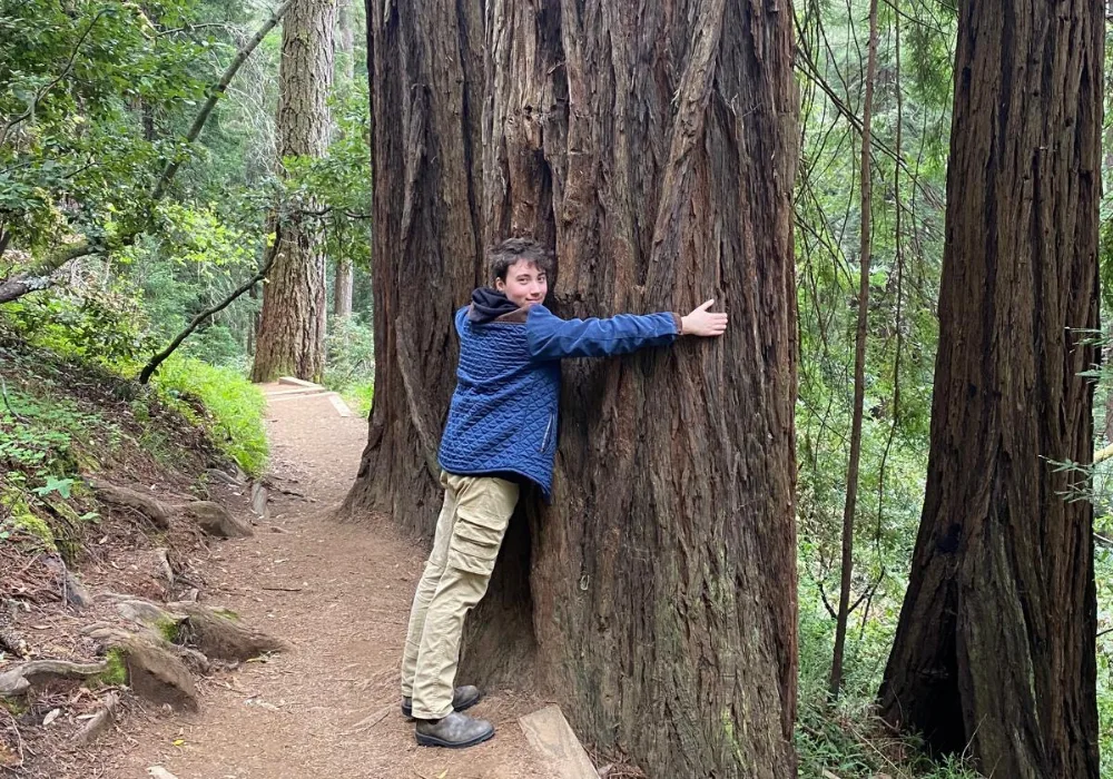 Photo de James en train d’enlacer un arbre