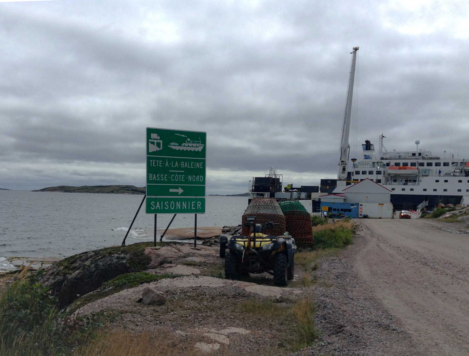 Un sentier qui mène à la côte de Tête-à-la-Baleine où un bateau attend.

