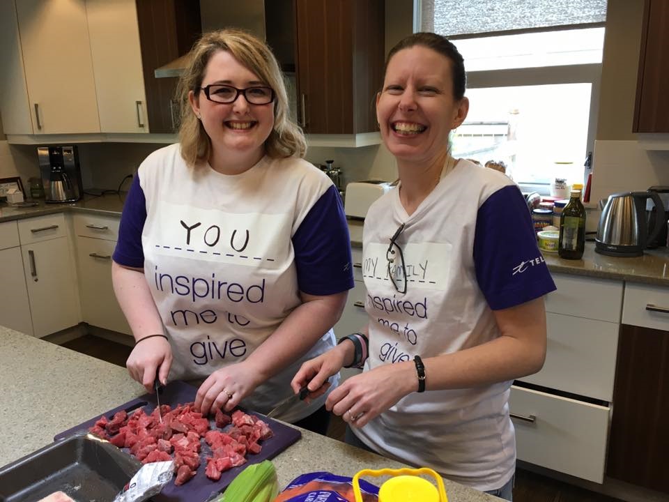 Two volunteers from TELUS preparing meals for families.