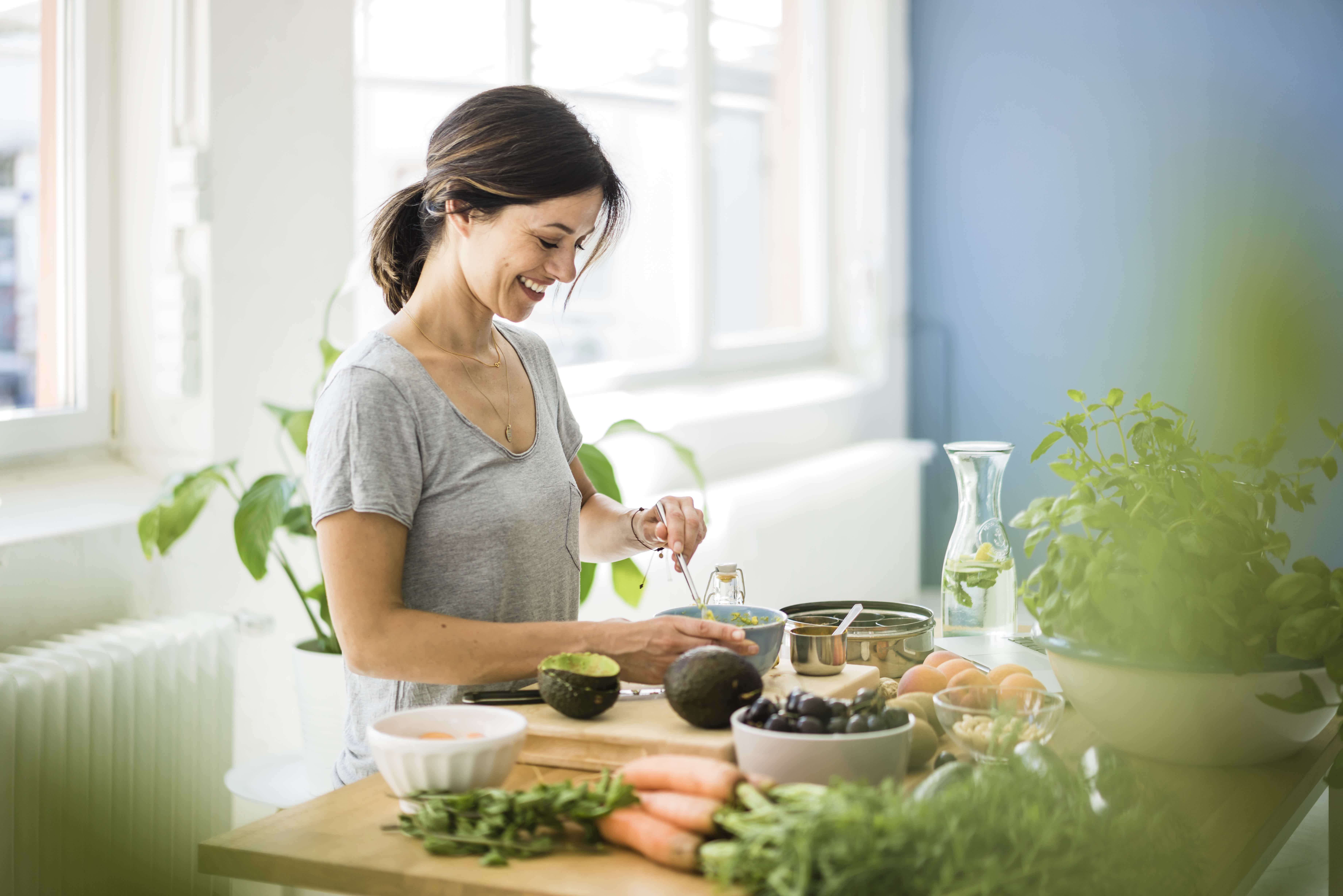 Une femme qui mange des aliments sains pour favoriser le renforcement de son système immunitaire.