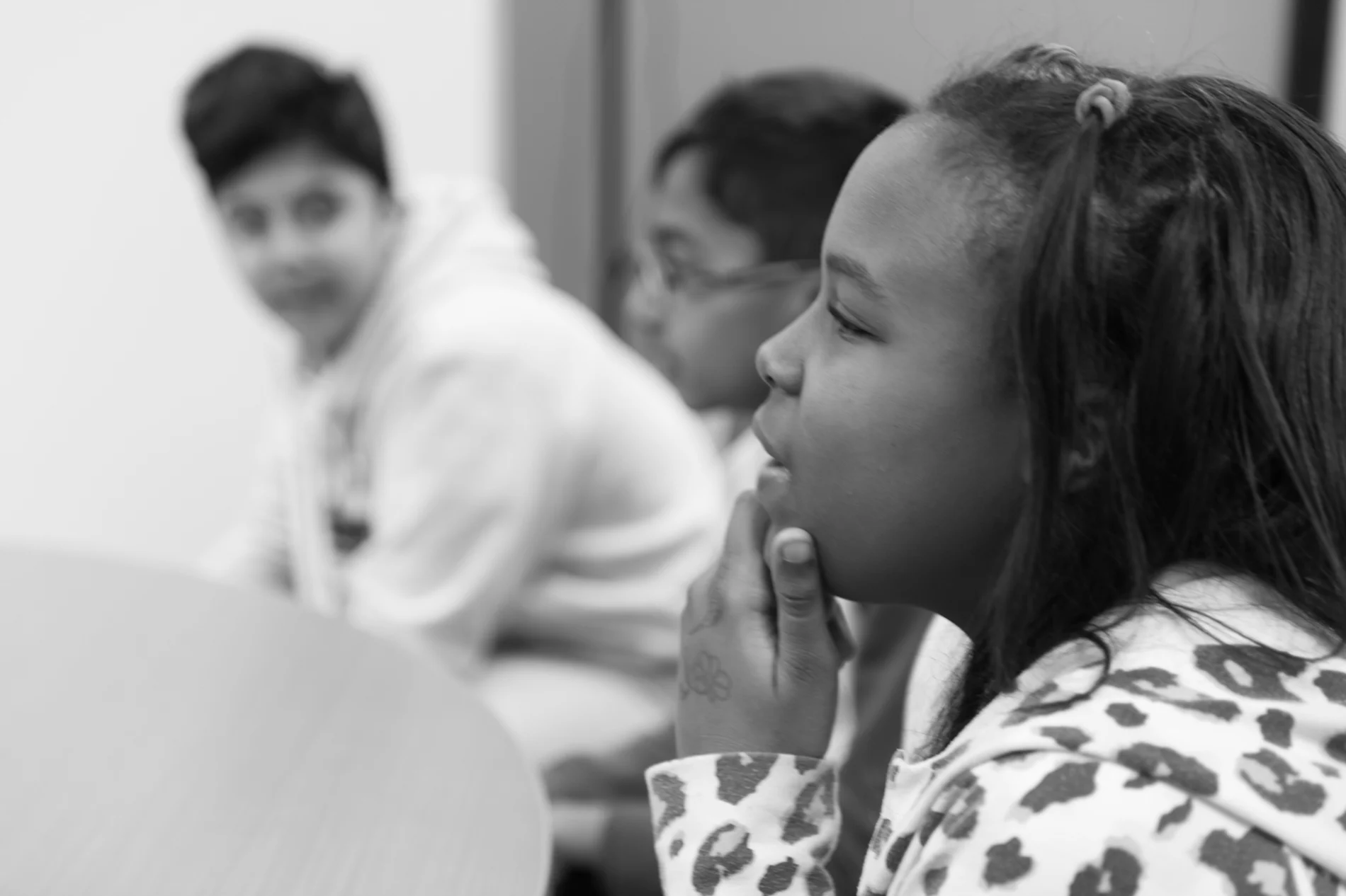 Trois jeunes étudiants dans une salle de classe.