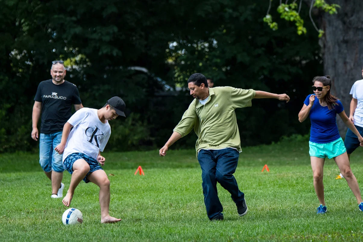 TELUS Digital team members play soccer outdoors