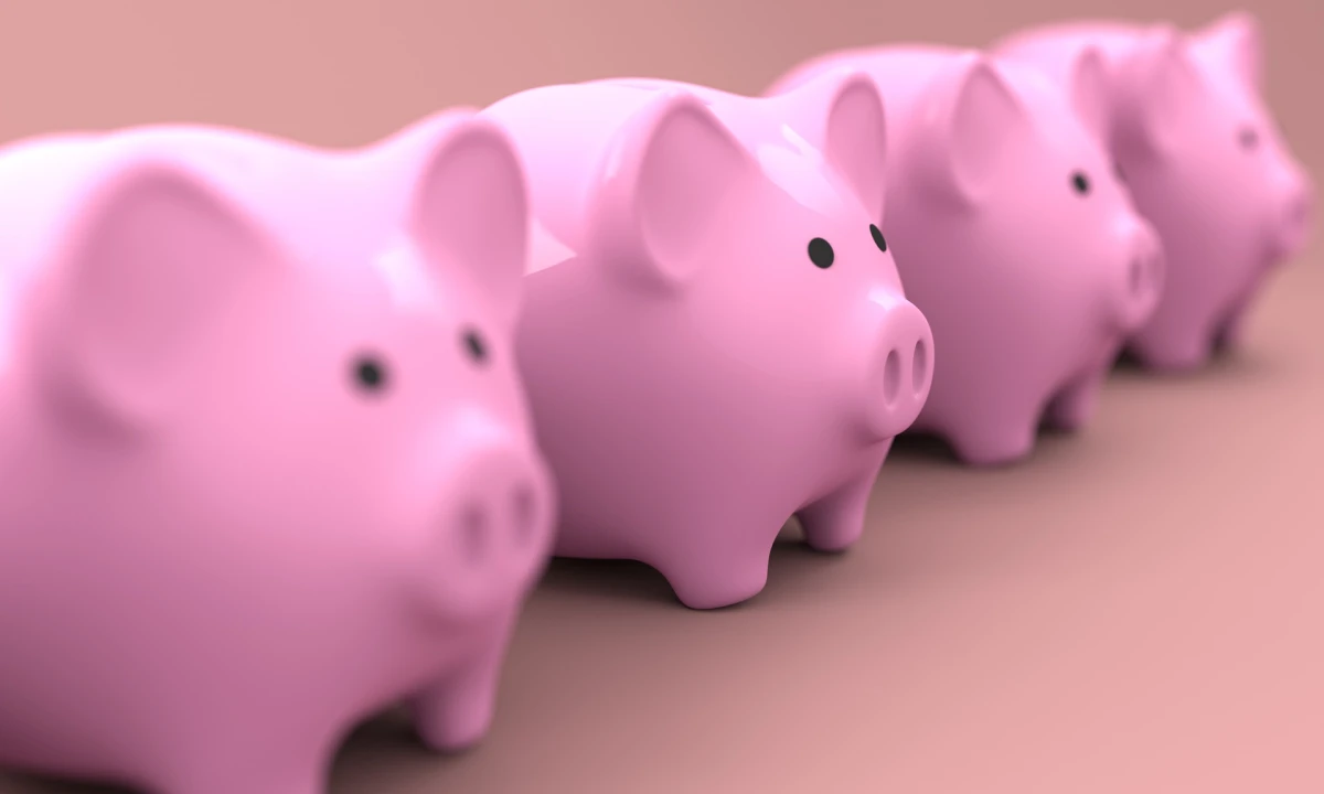 Four pink piggy banks lined up in a row.