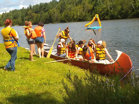 Enfants du camp embarquant dans un grand canot