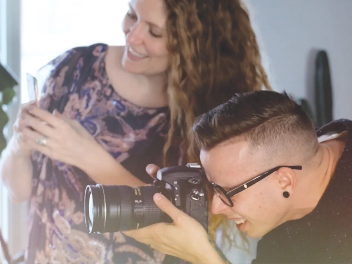 Two content creators taking pictures using a phone and a DSLR camera