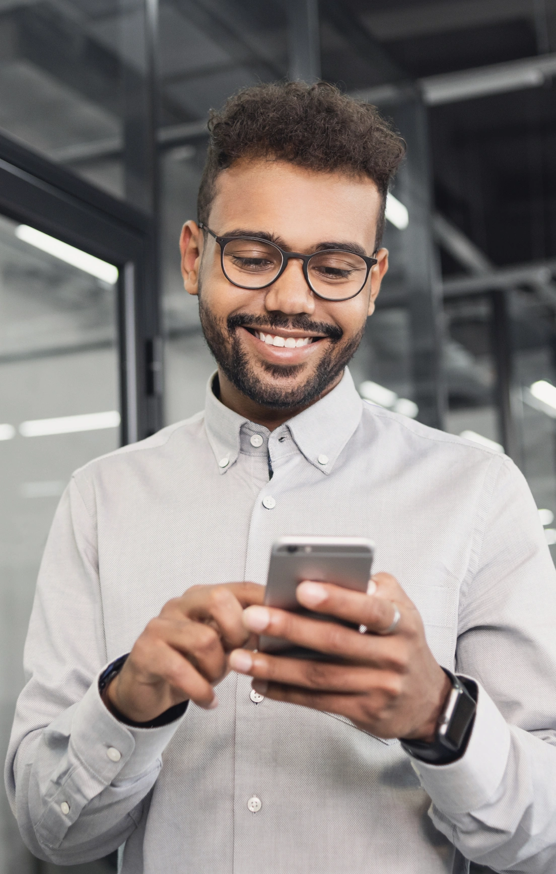 Image of a man smiling at his phone