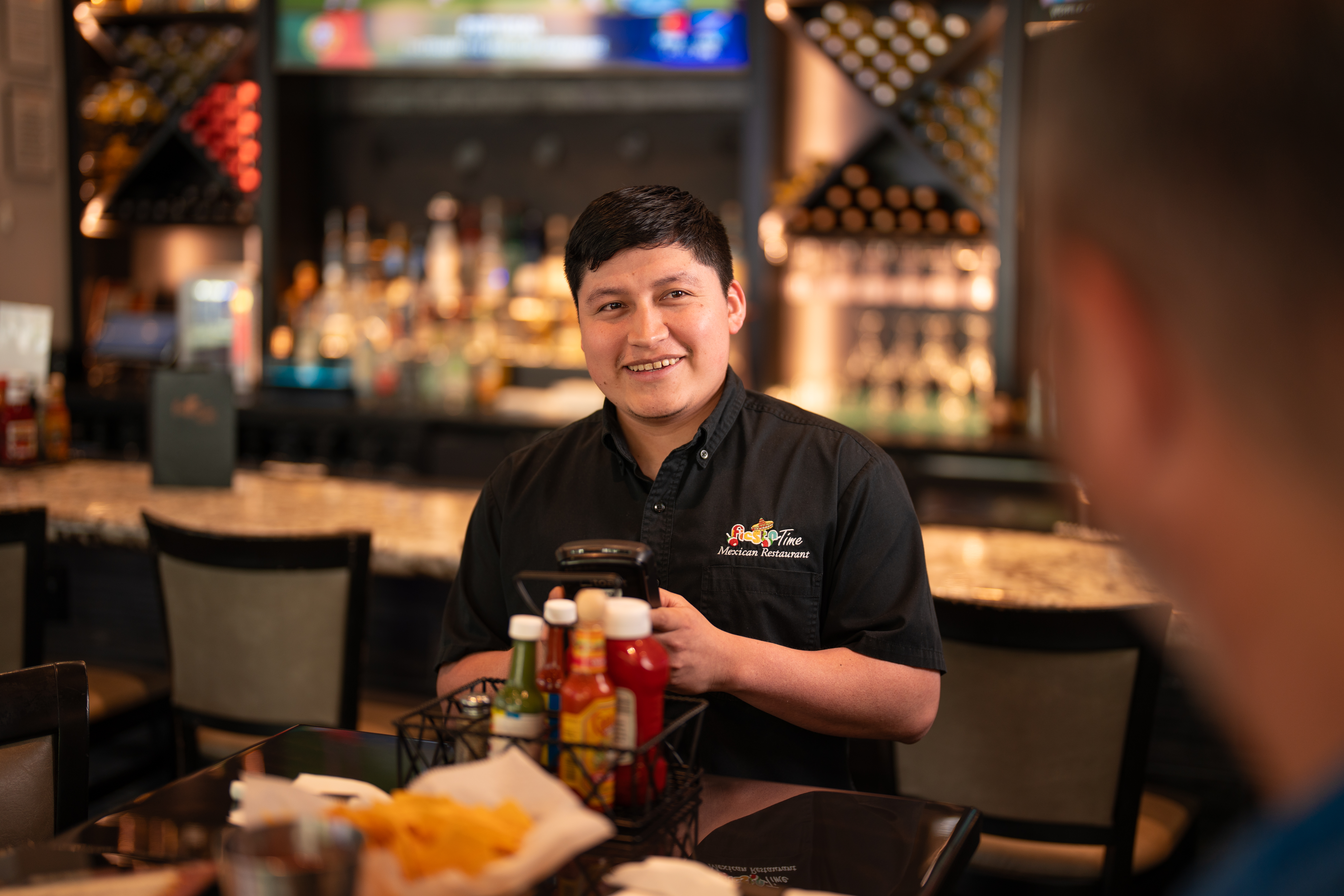 A team member at Fiesta Time Amigos taking a customer order with a Toast Handheld.