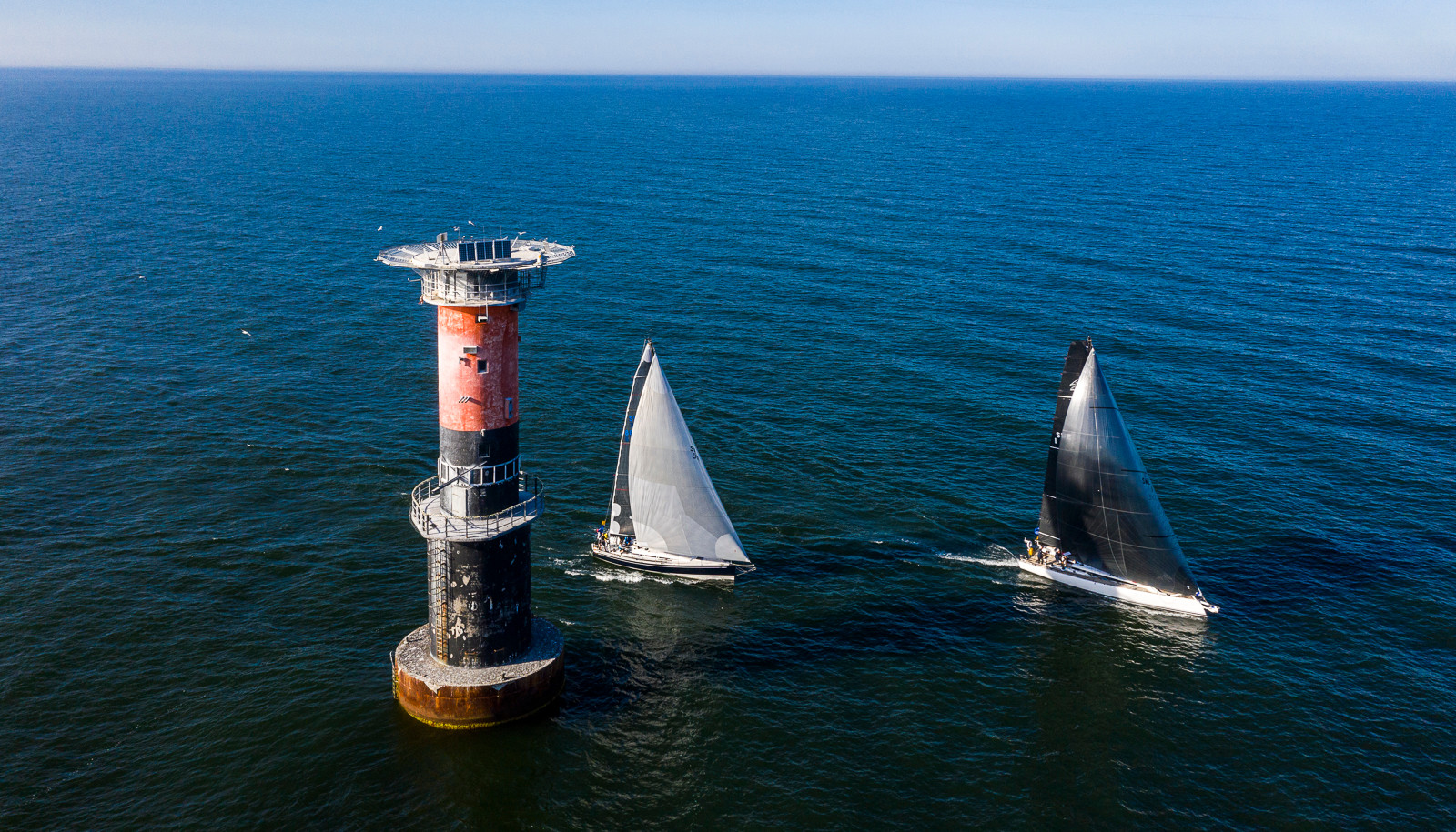 Offshore yacht heeling in breeze with sunset.
