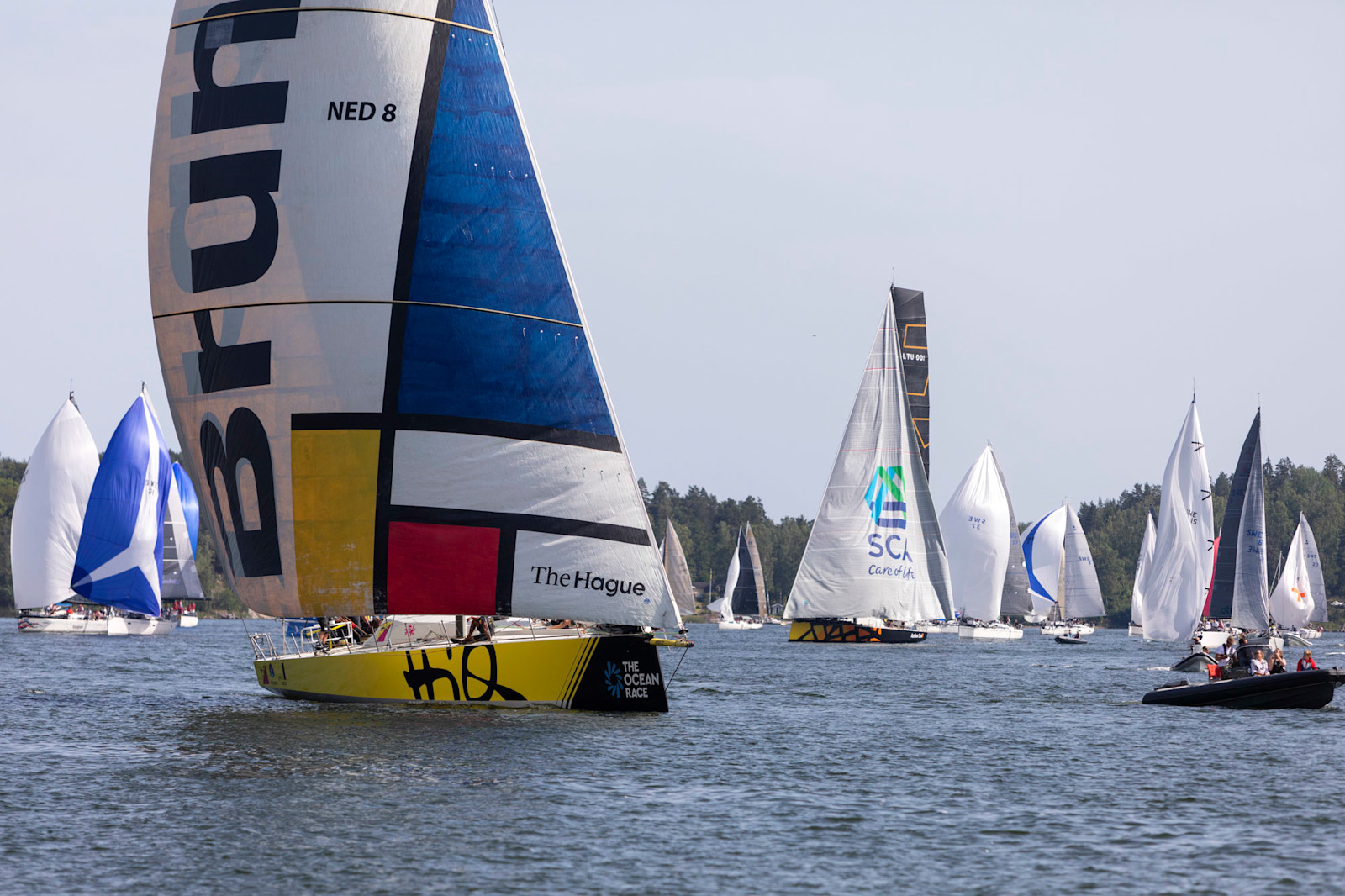 Lighthouse with yacht passing offshore.