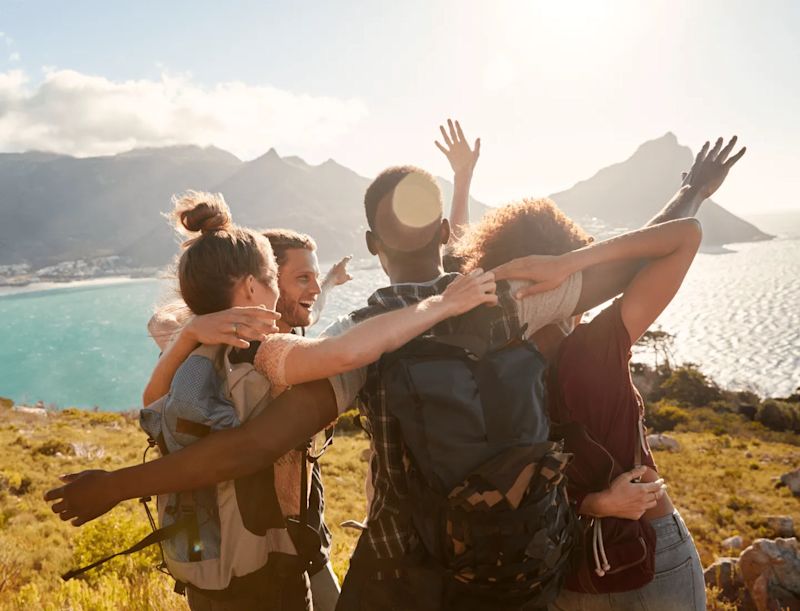 Friends hugging in front of a lake showing Our Sustainability Promise