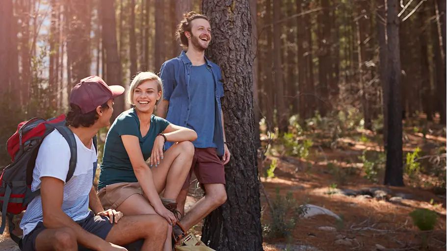 A group of people hiking together surrounded by trees