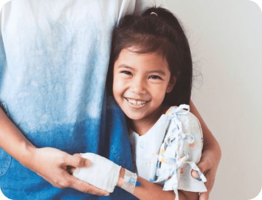 Young girl hugging adult with IV in arm