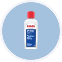 BAND-AID antiseptic cleansing liquid bottle with red cap, recommended for gently washing the area or applying an antiseptic wash to avoid bursting blisters.