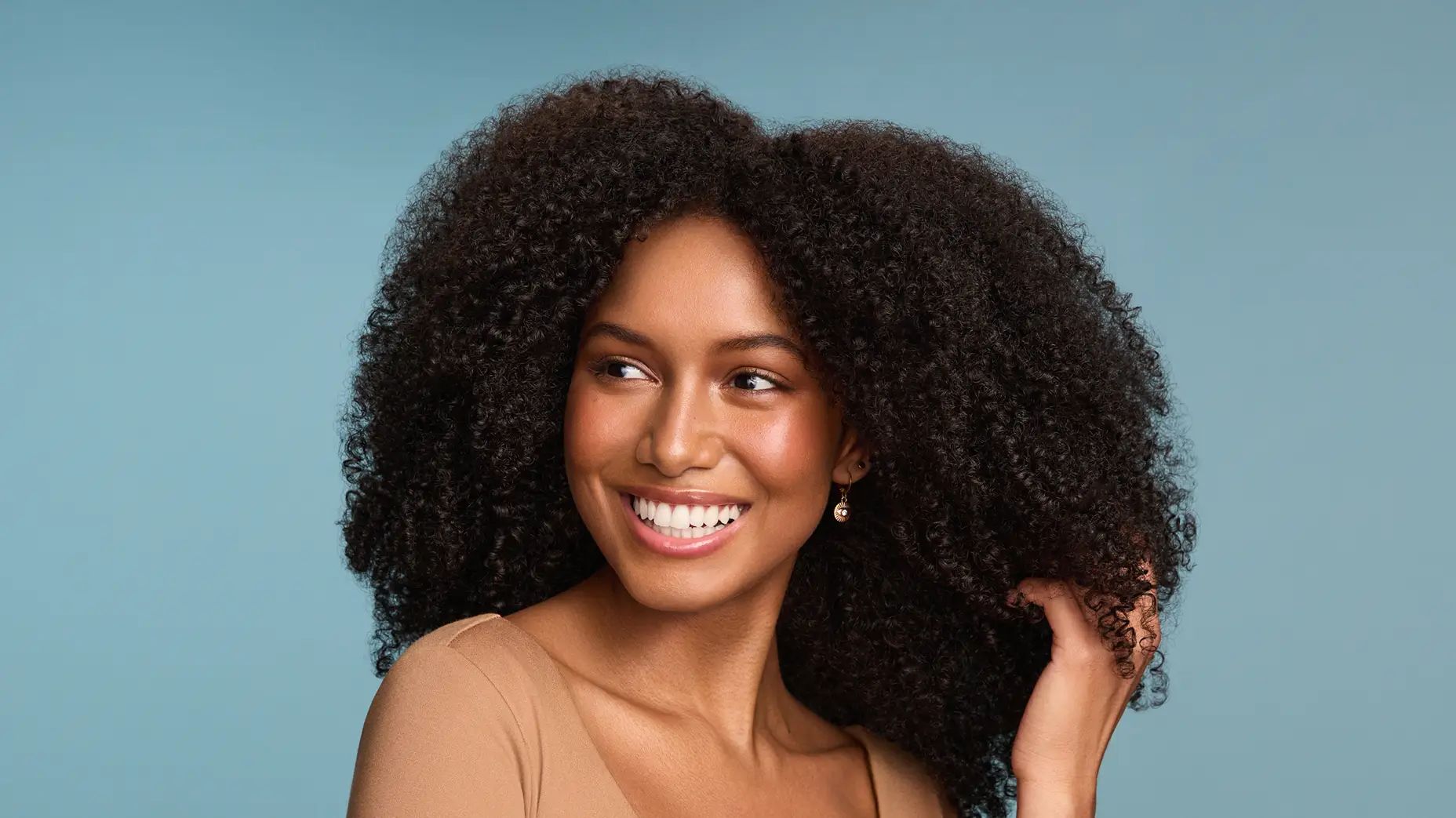  Smiling woman with healthy coils after using Maui Moisture® Products