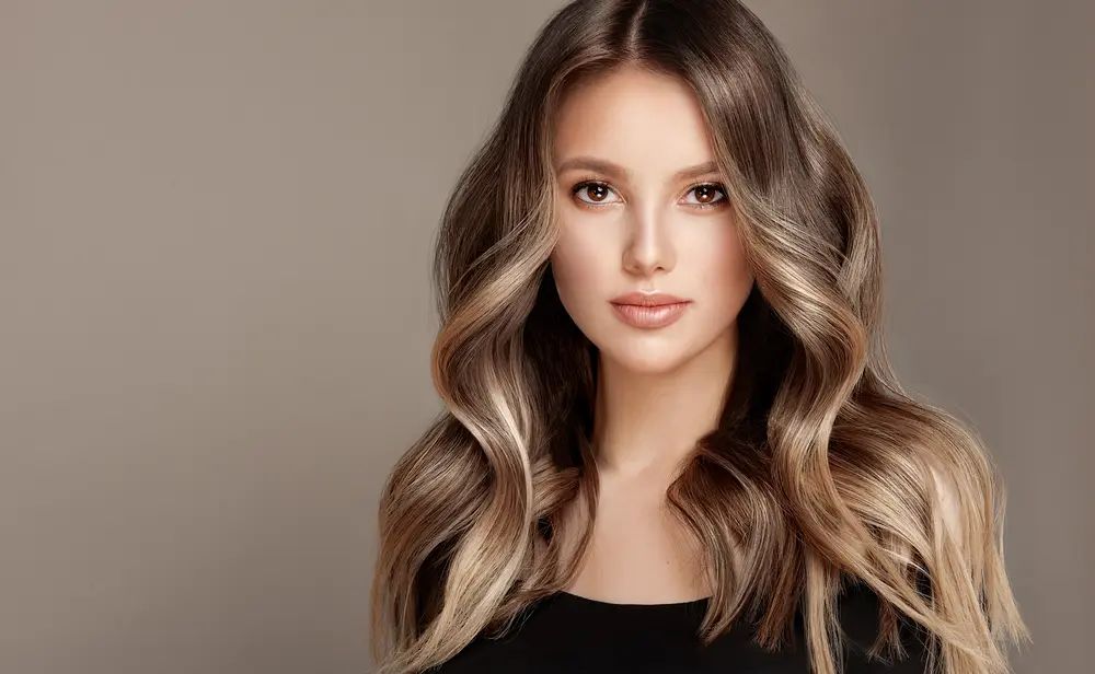 Woman with healthy blonde straight wavy hair after using Maui Moisture® products