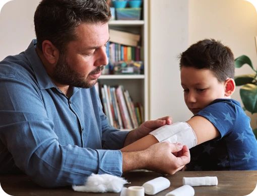 Dad bandaging his son’s arm.