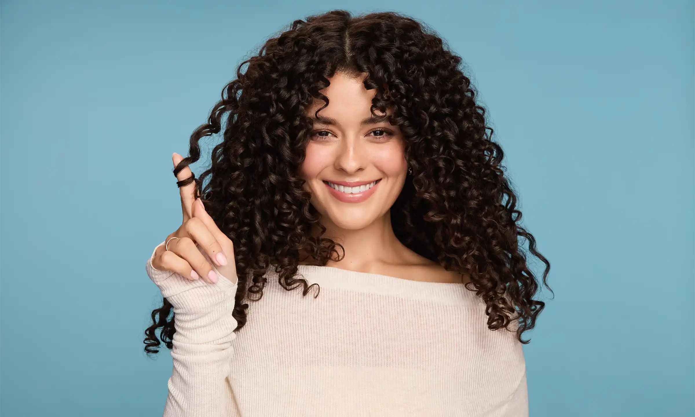 Woman with healthy curls touching her hair