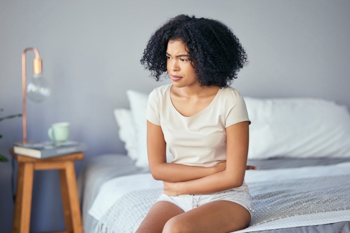 Frau sitzt mit Tee auf Sofa