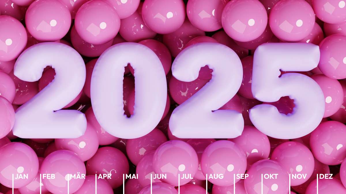 Vier rosa Luftballons in der Form der Jahreszahl 2025 liegen auf einer Vielzahl weiterer runder Luftballons.