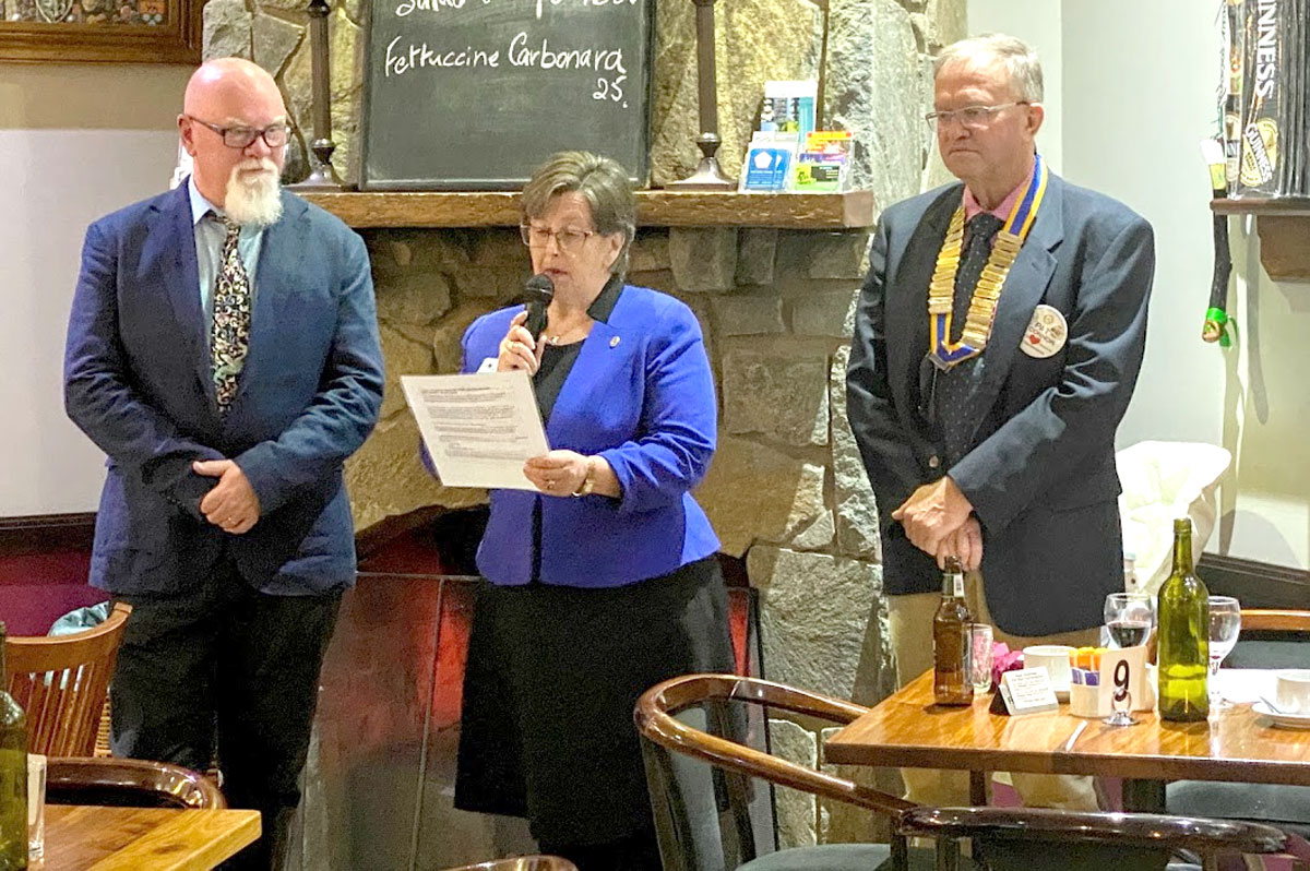 Outgoing Assistant District Governor Julie Poplin transferring presidentship from Pat O'Connor (right) to Craig Nicholls (left).
