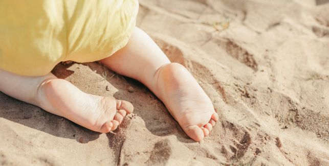 bébé marchant à quatre pattes sur le sable