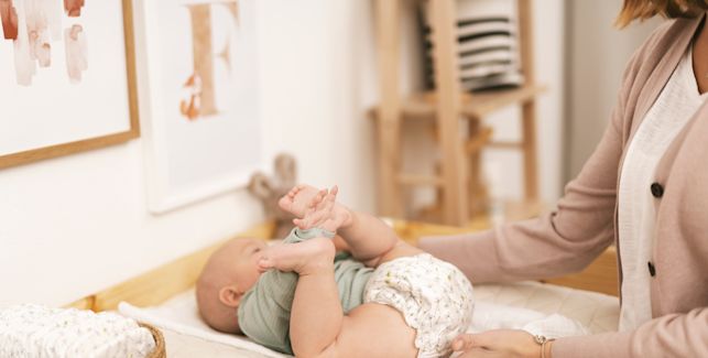 Mamá cambiando pañal a su bebé