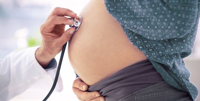 médecin auscultant une femme enceinte