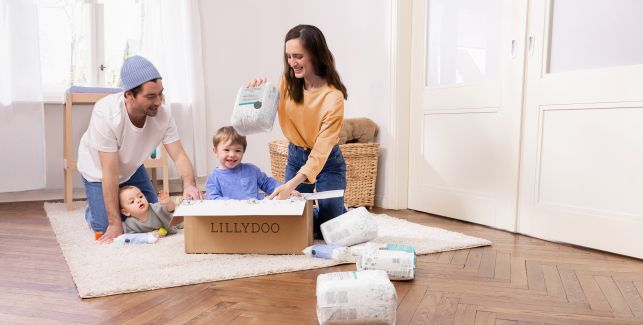 Mamá, papá y dos niños pequeños abriendo la caja mensual de pañales LILLYDOO