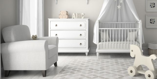 Babyzimmer in weiß mit Babybett, Sessel, Kommode und Schaukelpferd. 