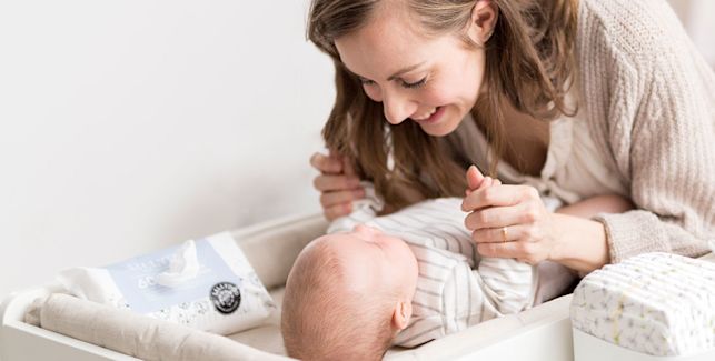 Bébé allongé sur la table à langer et sa maman