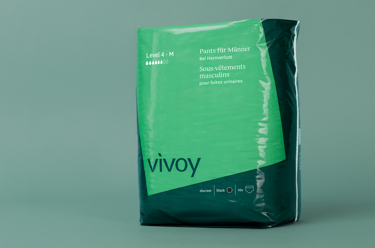 Grünes Paket der Vivoy Pants für Herren steht vor grünem Hintergrund.