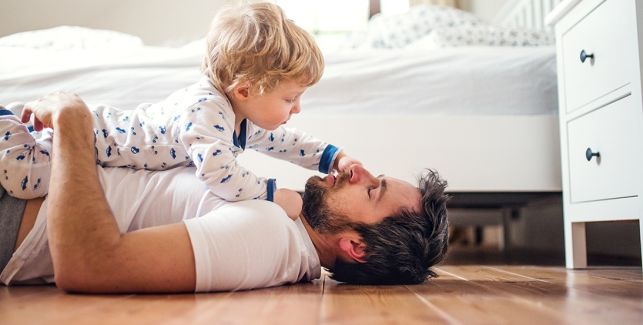 Père et fils en train de jouer sur le sol