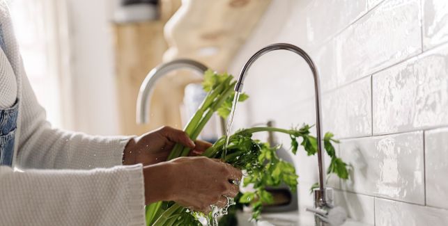 Una mujer lava unas verduras
