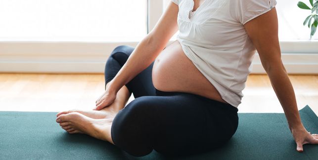 Schwangere Frau beim Sport auf einer Yogamatte