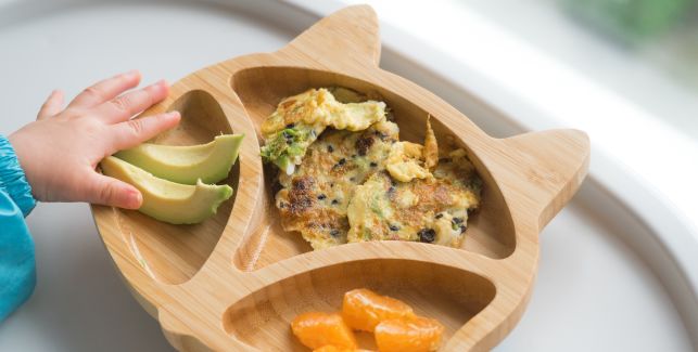 assiette avec repas bebe contenant avocat, clémentine et galette de légumes