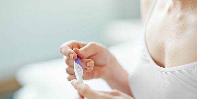 femme tenant dans les mains un test de grossesse